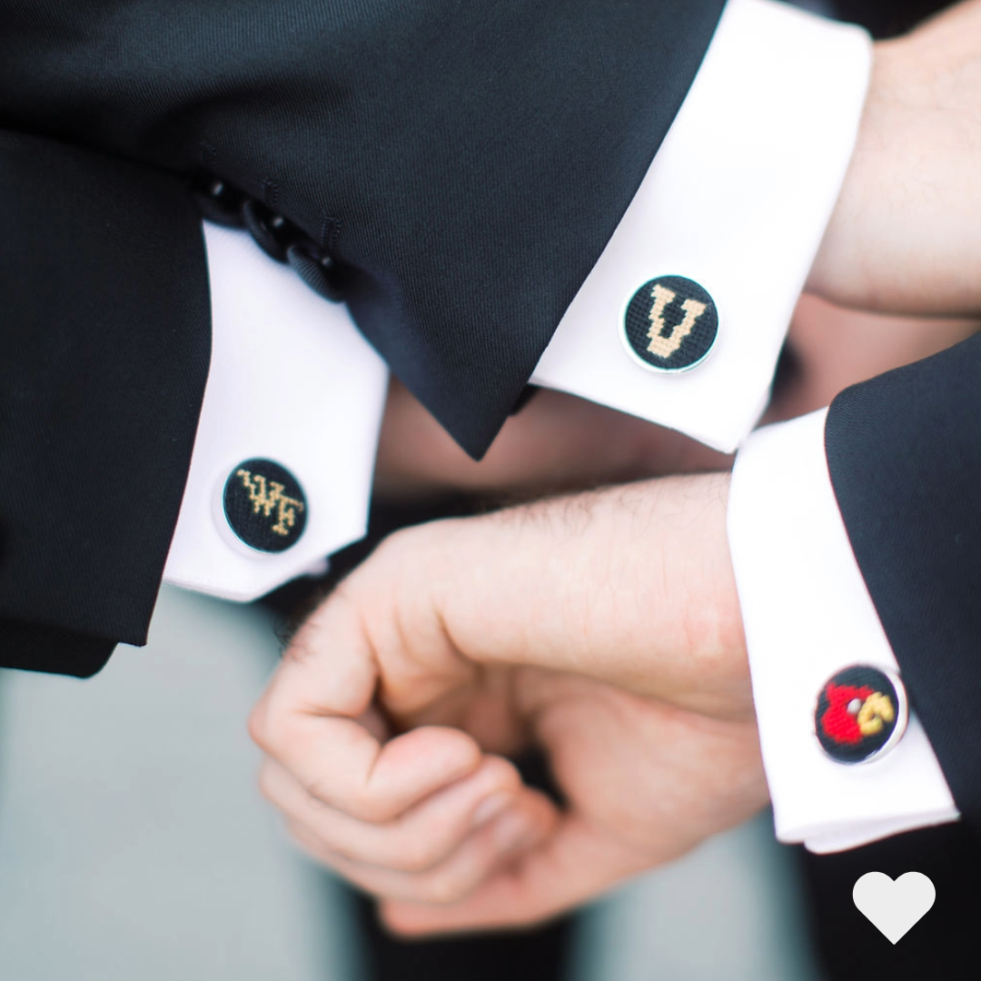 Groomsmen showing their cufflinks of their colleges.
