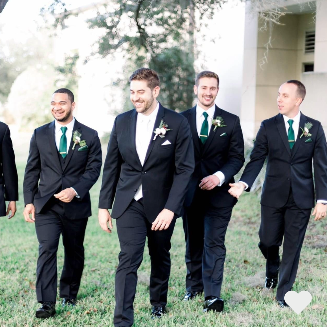 A groom walking with his groomsmen outside on his wedding day.