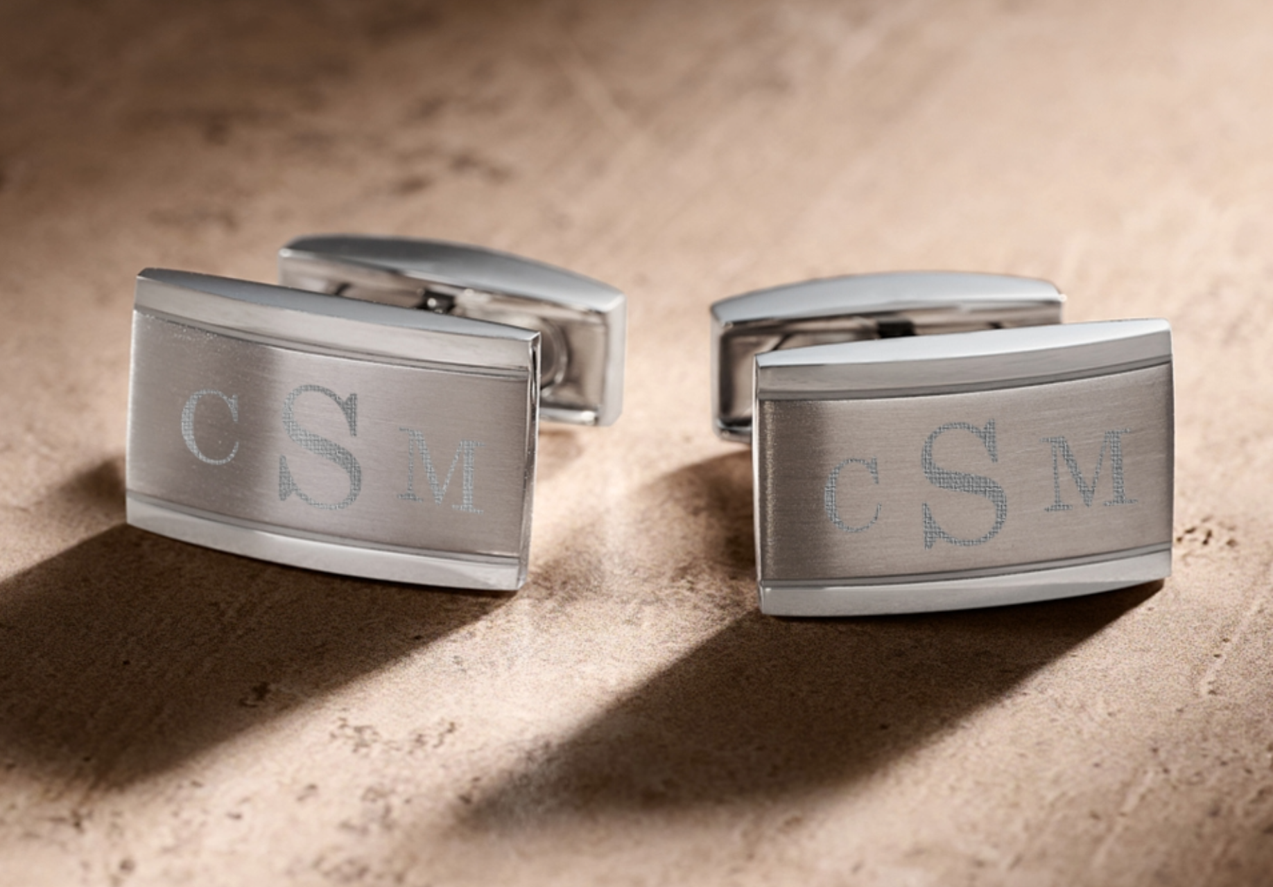 Custom USAID Cufflinks on a gray table and gray background.